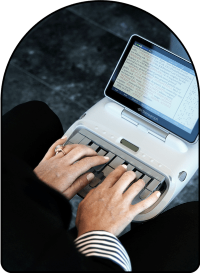 woman's hands typing on stenograph machine